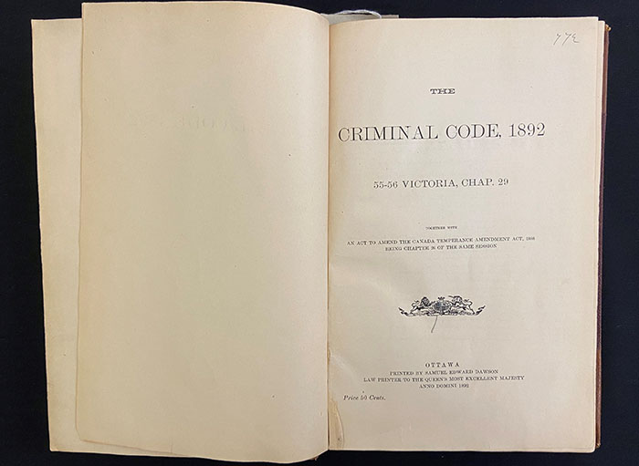 Livre ancien intitulé The Criminal Code, 1892, ouvert à la page de titre.