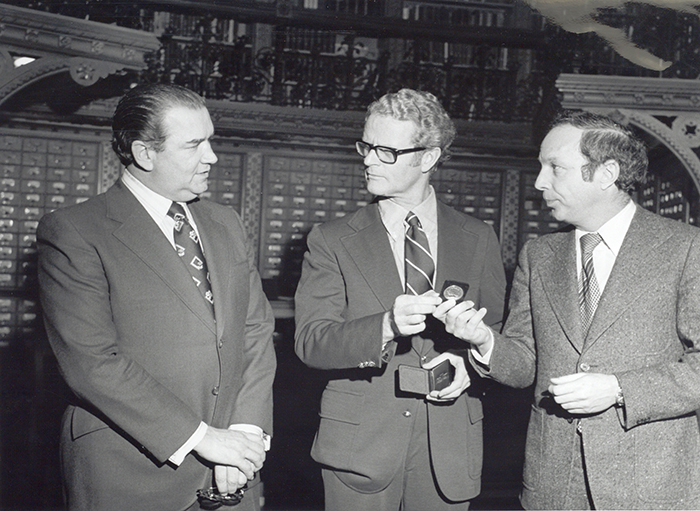 Yvon Gariépy presents the 100th anniversary coin to Erik Spicer and Gilles Frappier in 1976